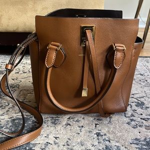 Michael Kors Collection luggage tan colored top handle bag with shoulder strap.